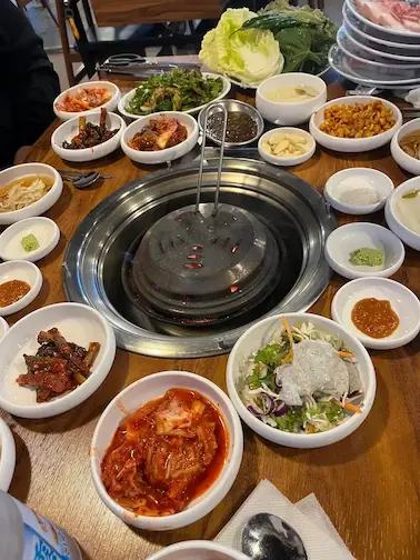 Typical Korean barbecue table setting with side dishes, sauces and shared plates in a local restaurant