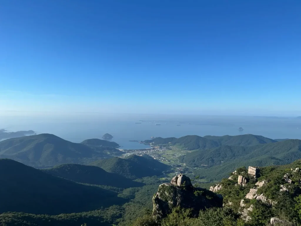 Coastal mountain view in Korea with blue sky, sea, and green hills